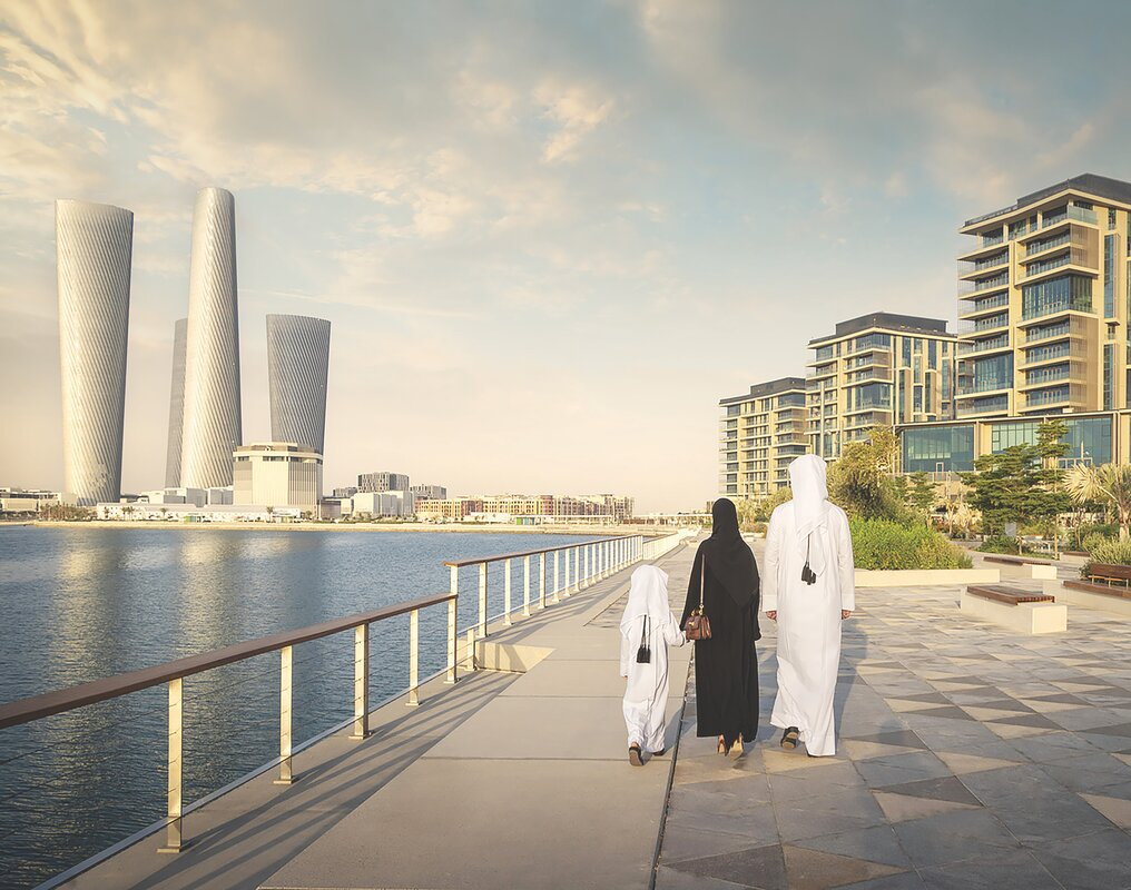 Family walking along a waterfront promenade in Qatar